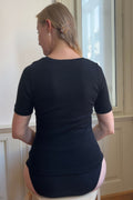 Modelka Jana má na sebe čierne merino tričko s krátkym rukávom - pohľad zozadu